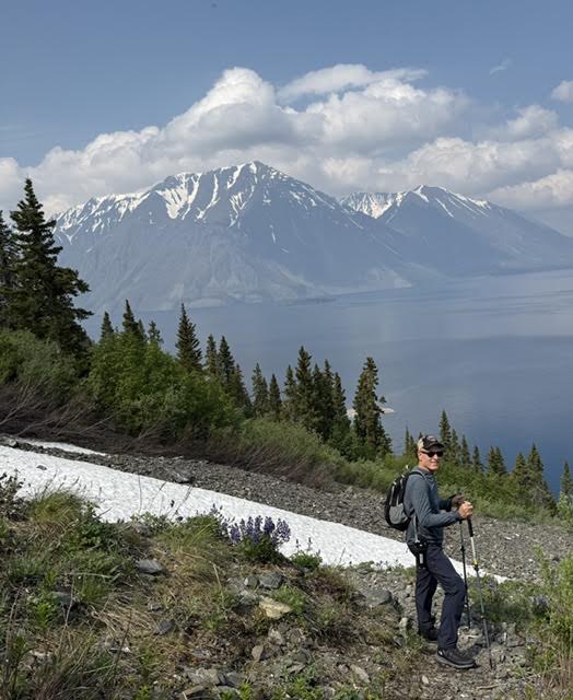 Steve hiking beside a mountain lake